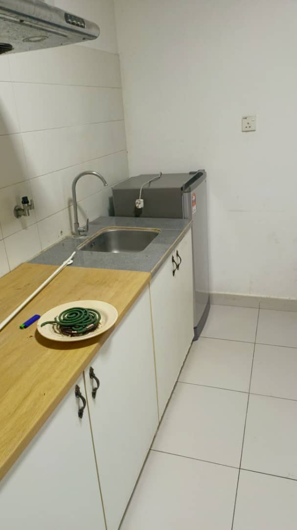 Kitchen with wooden countertop, sink, and tiled floor.