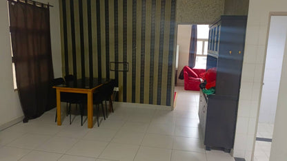 Living room with striped wall, table, chairs, and a red sofa.